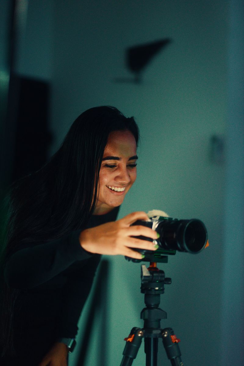 Aluna sorrindo atrás da câmera