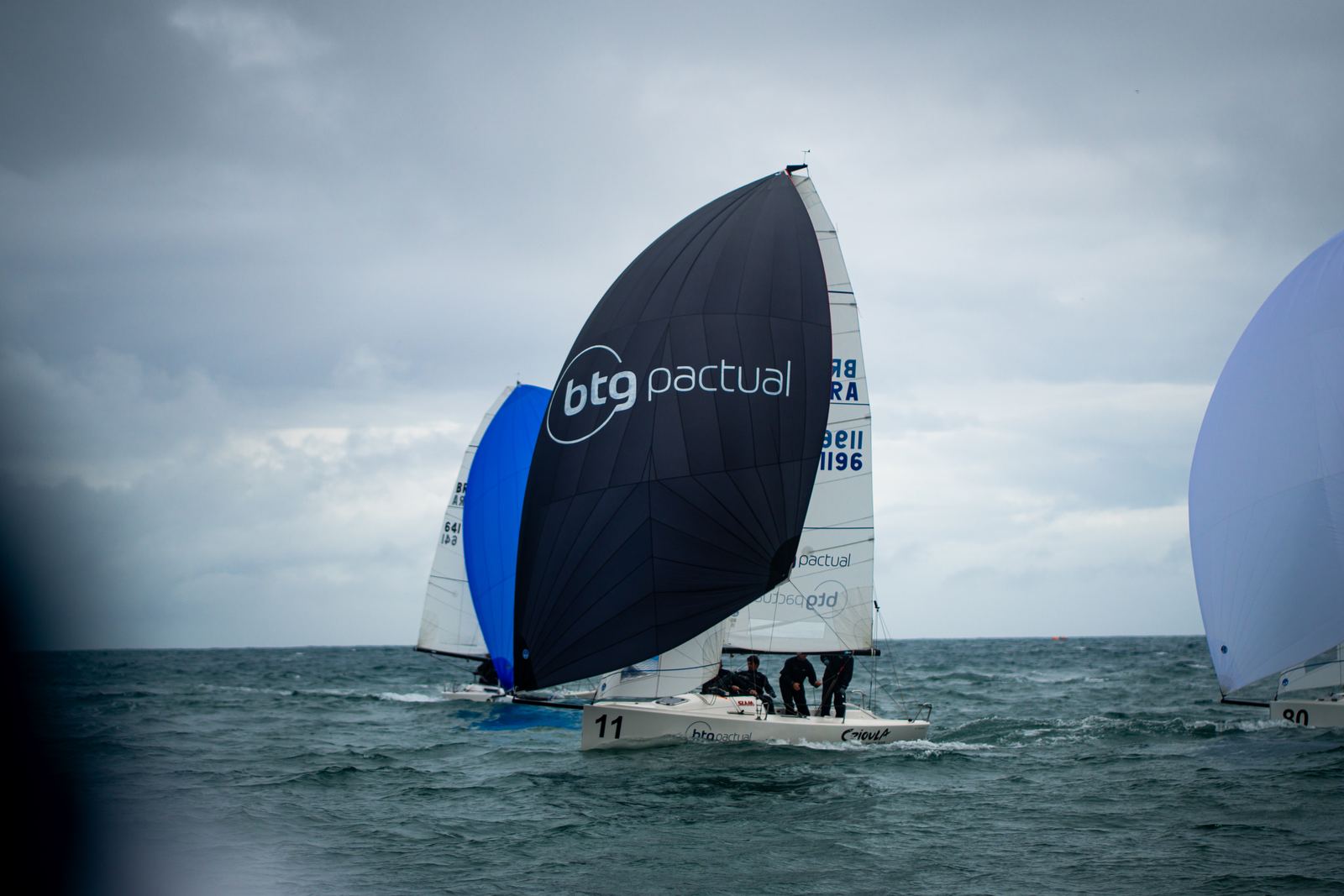 Veleiro de vela preta em regata