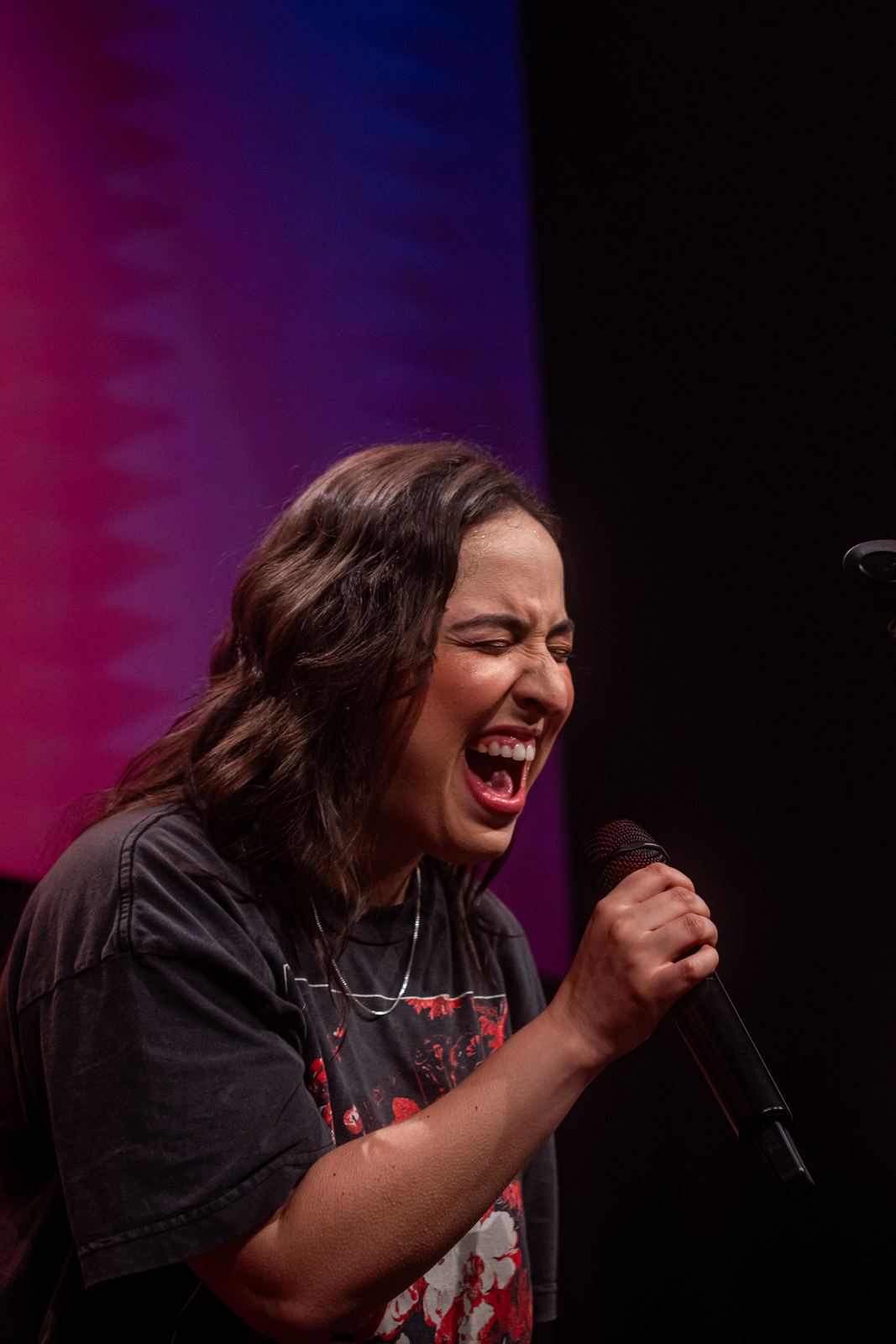 Cantora em show ao vivo com luz magenta