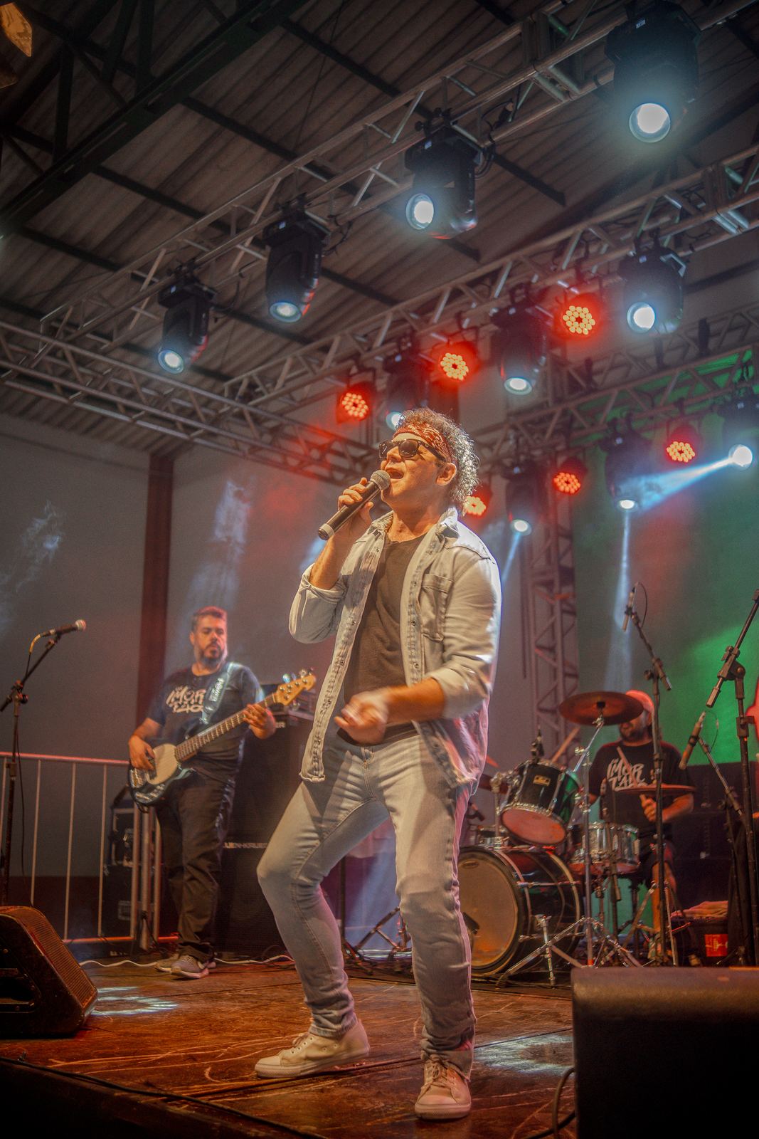 Cantor no palco em festa com luzes vermelhas