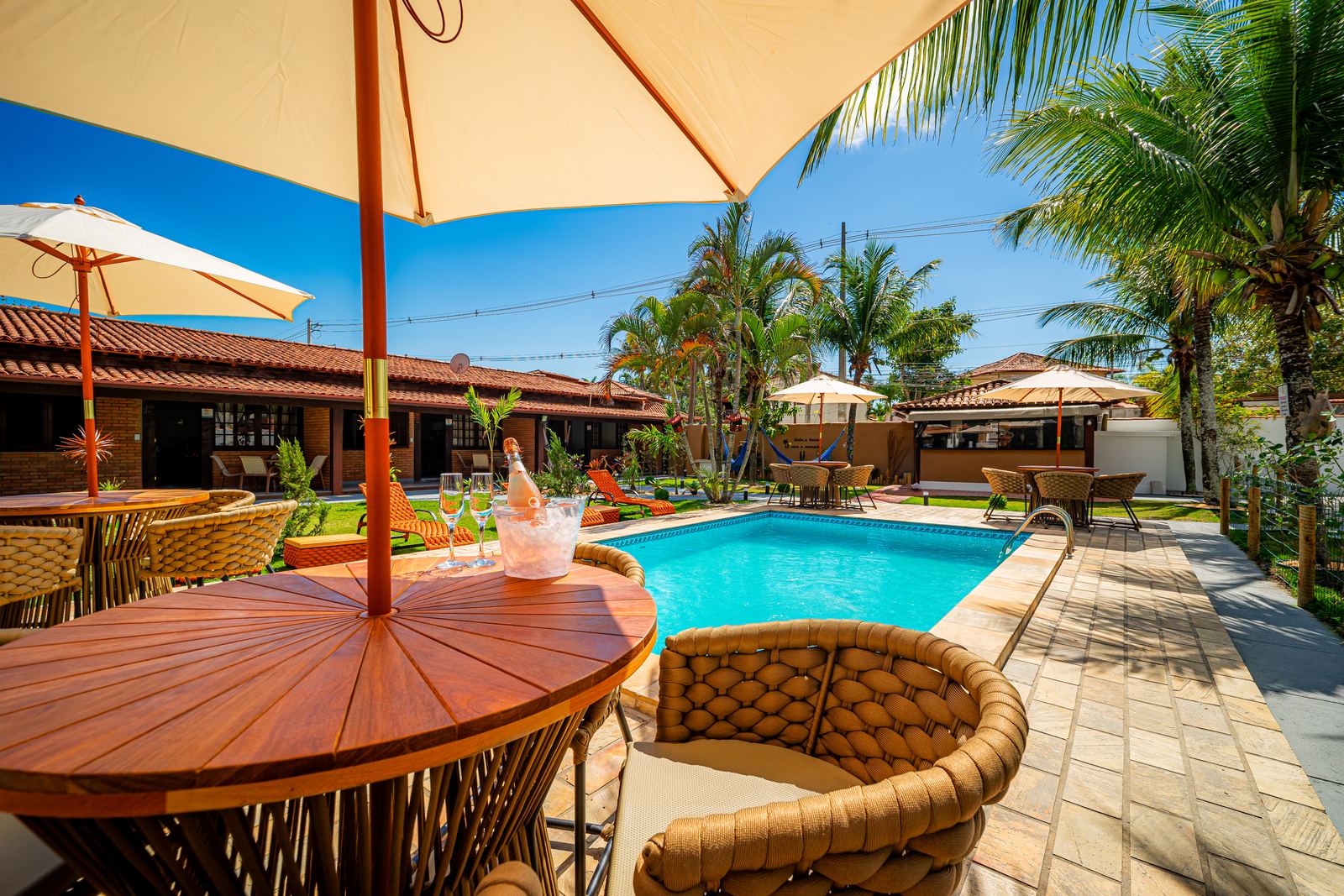 Área de piscina de pousada com guarda-sol