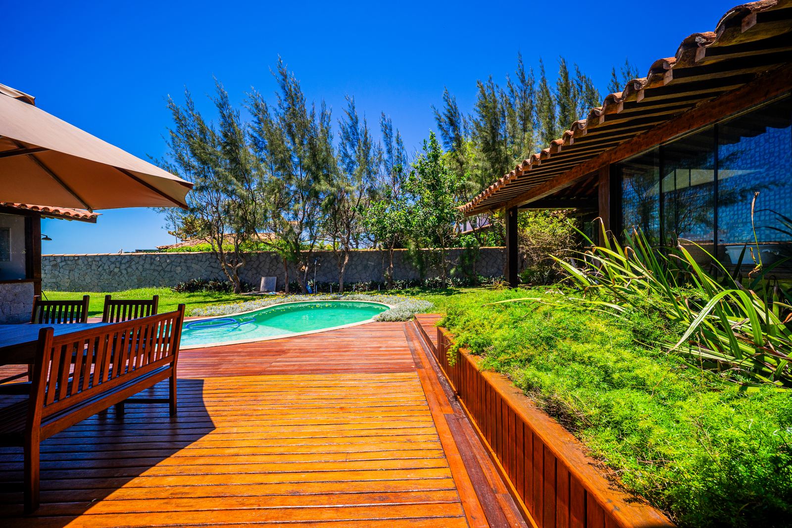 Deck de madeira com piscina e jardim
