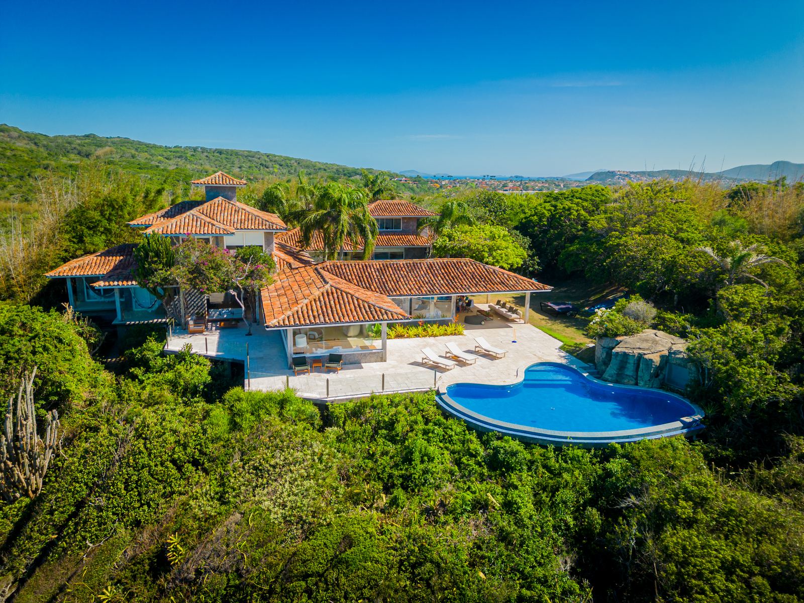 Casa com piscina no alto da colina e vista para o mar