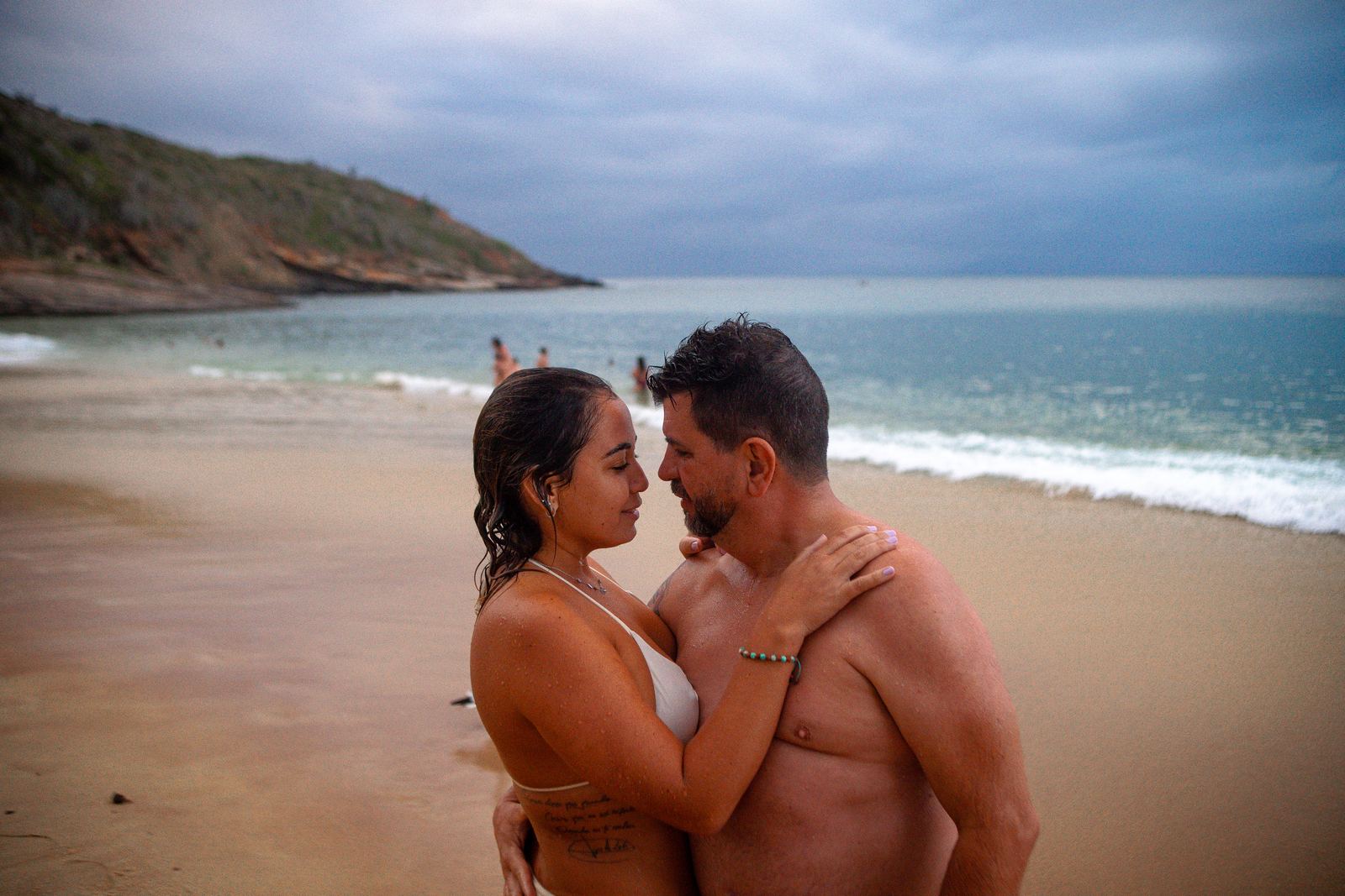 Casal na praia em dia nublado